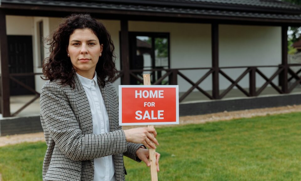A Real Estate Agent Holding a Sign