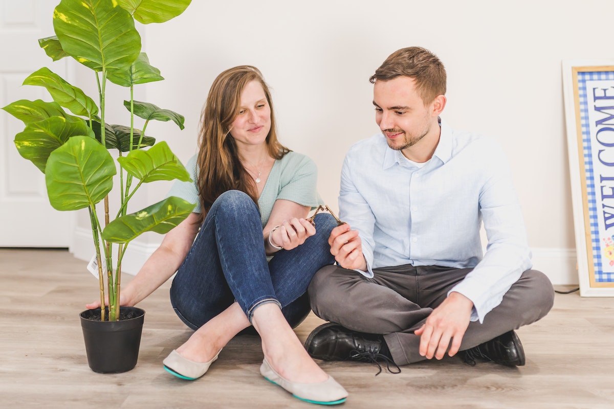 Man and Woman Sitting on the Floor while Holding Keys