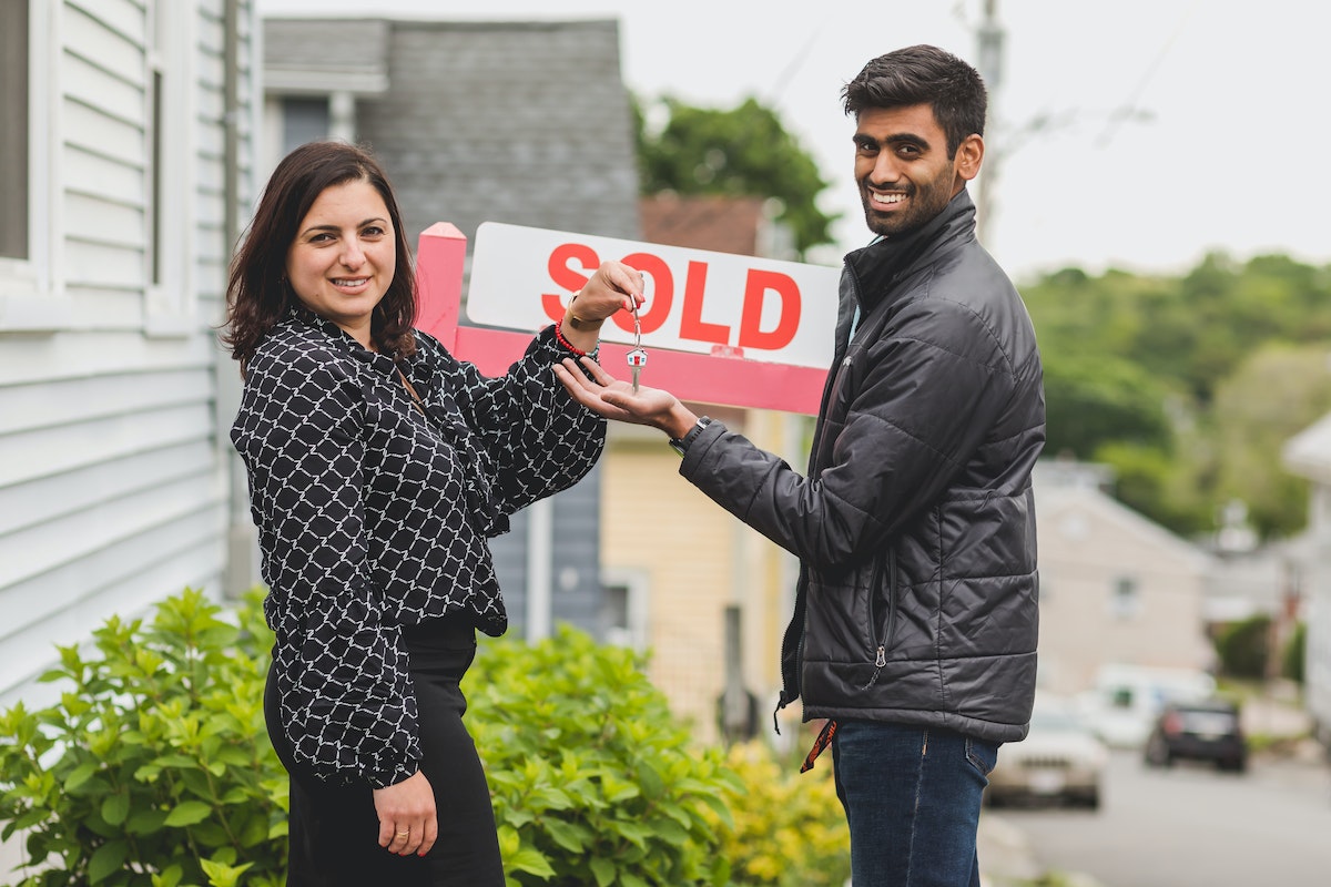 Real Estate Agent Handing the Key to Her Client